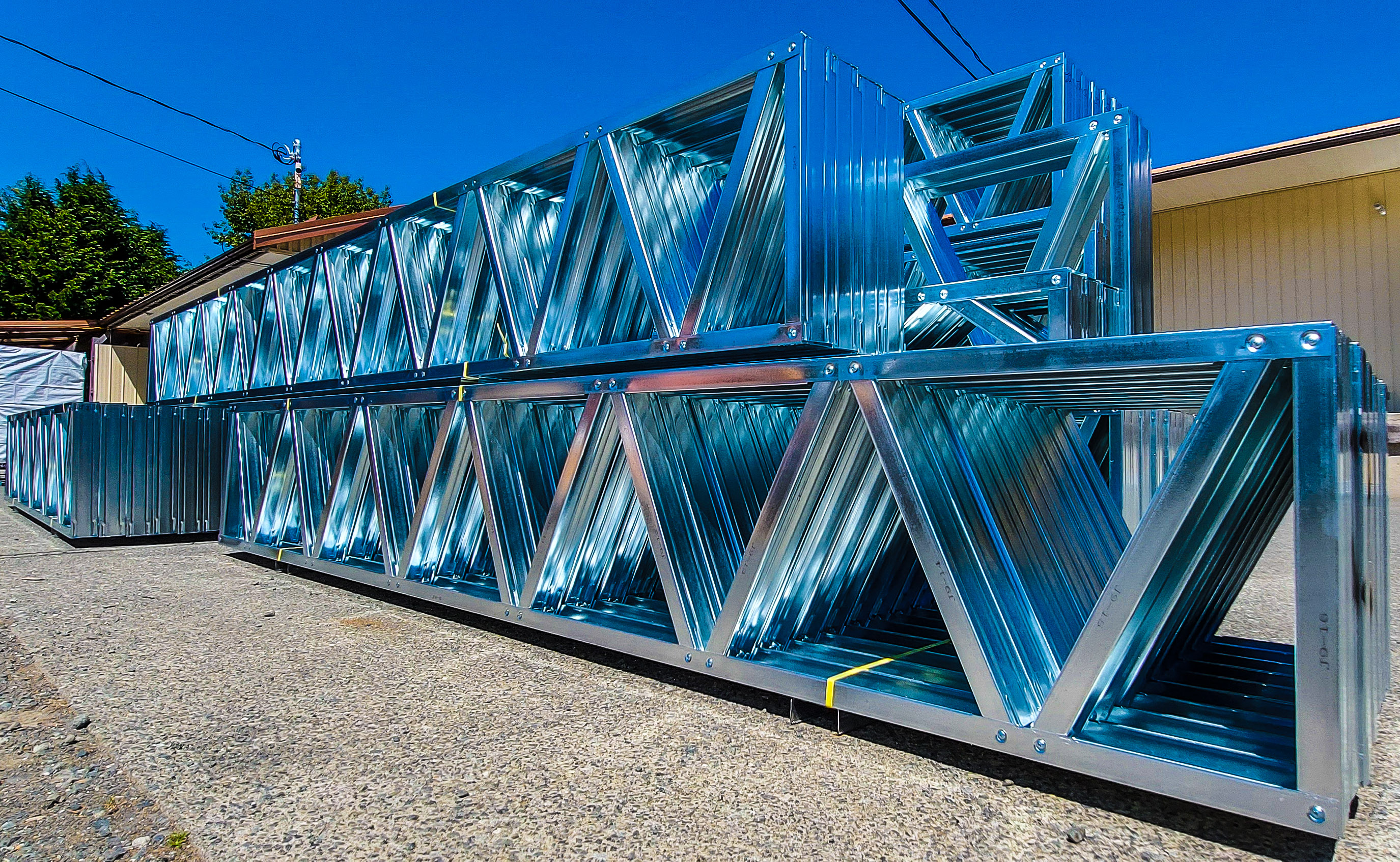 Stacked CNC-fabricated steel trusses ready for delivery
