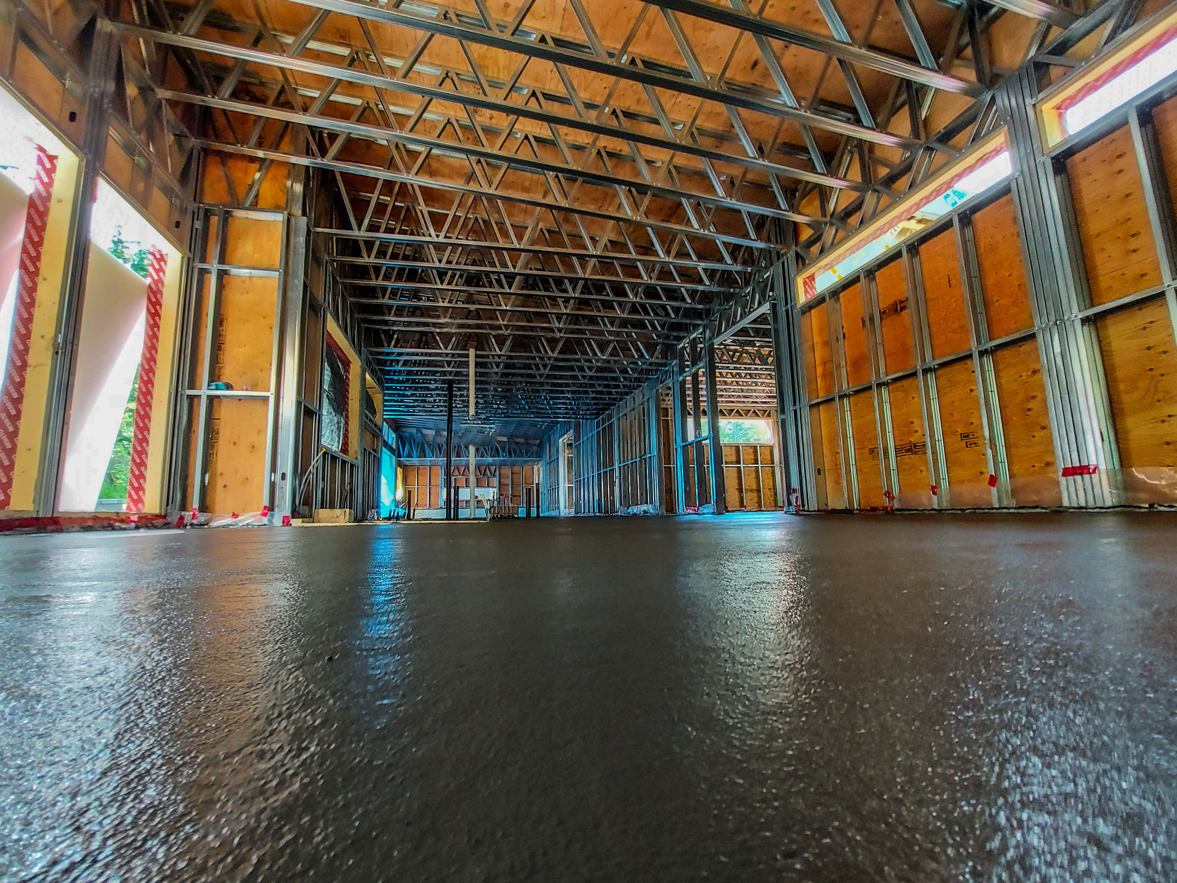 Interior with steel framing and wood sheathing on concrete floor
