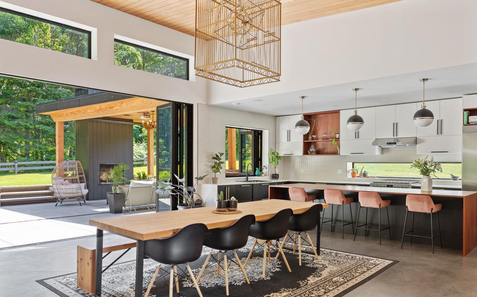 Open dining and kitchen with folding glass wall onto a covered patio