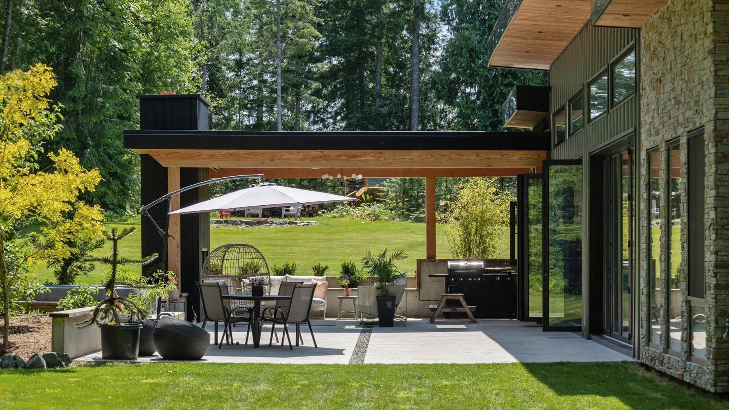 Covered patio with outdoor kitchen, dining area and folding glass doors to the house
